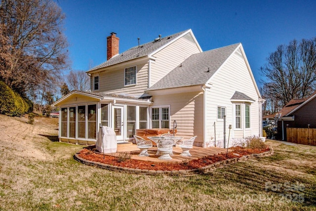 back of property with a yard, a patio, and a sunroom