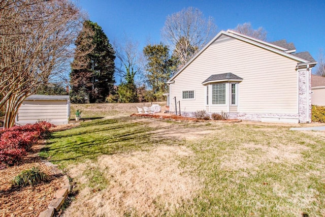 exterior space featuring a lawn and a storage shed