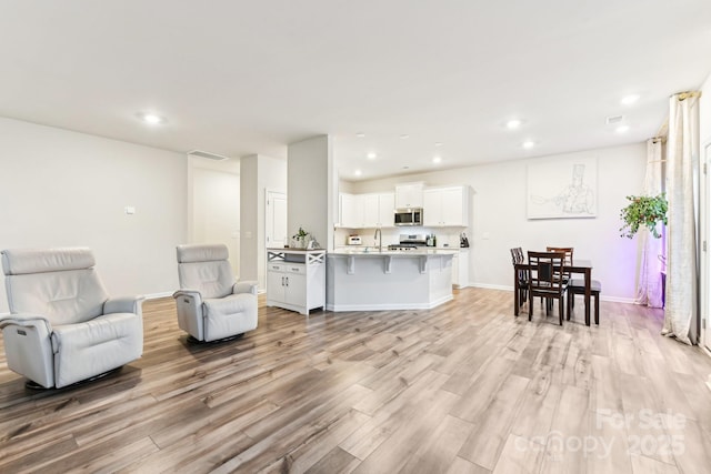 living room with light wood-type flooring and sink