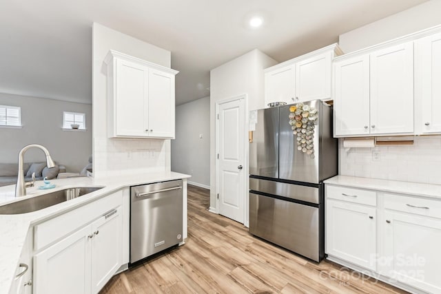 kitchen featuring backsplash, sink, white cabinets, and stainless steel appliances