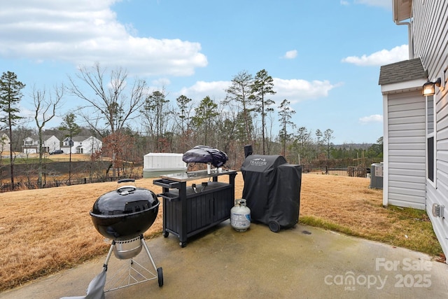 view of yard featuring a storage unit, cooling unit, and a patio