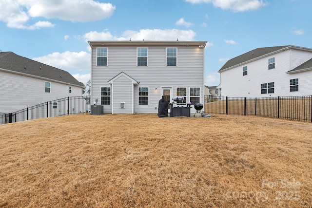 rear view of house featuring a yard and central AC