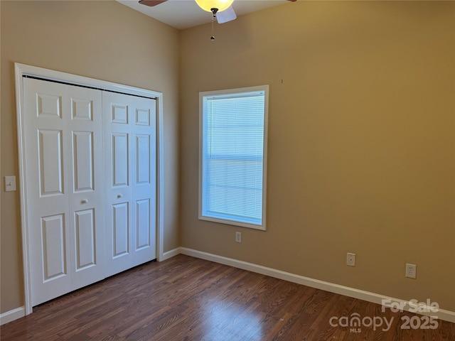 unfurnished bedroom featuring ceiling fan, a closet, and dark wood-type flooring