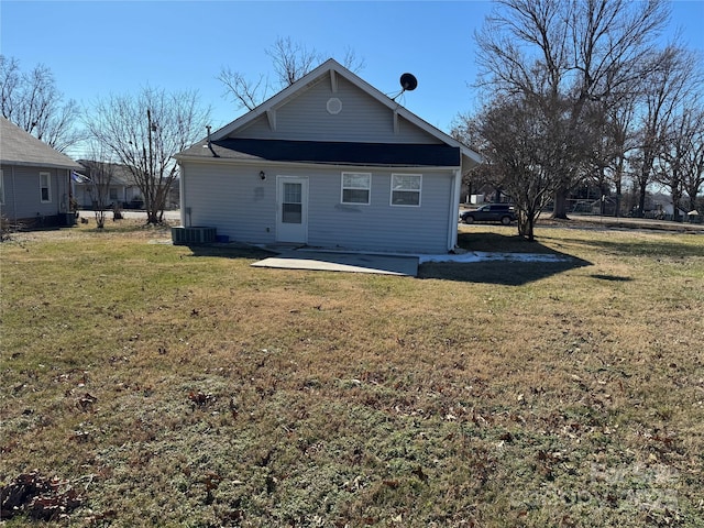 rear view of property featuring a lawn, central air condition unit, and a patio area