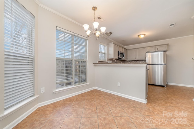 kitchen featuring stainless steel appliances, kitchen peninsula, backsplash, pendant lighting, and a notable chandelier