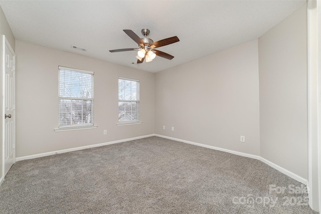 empty room with a textured ceiling, ceiling fan, and carpet