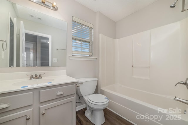 full bathroom with toilet, hardwood / wood-style flooring, a textured ceiling, shower / bathing tub combination, and vanity