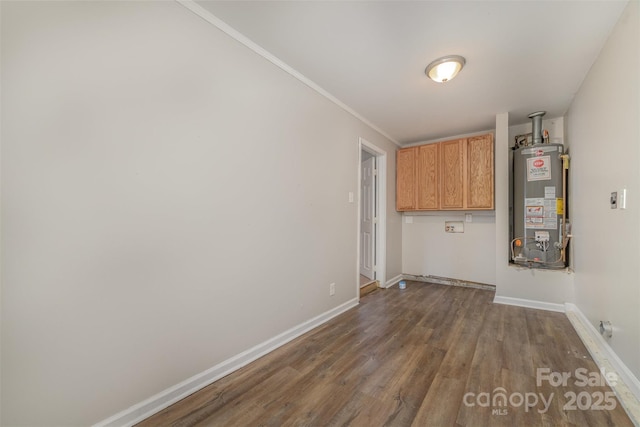 laundry area with water heater, hardwood / wood-style flooring, cabinets, and ornamental molding