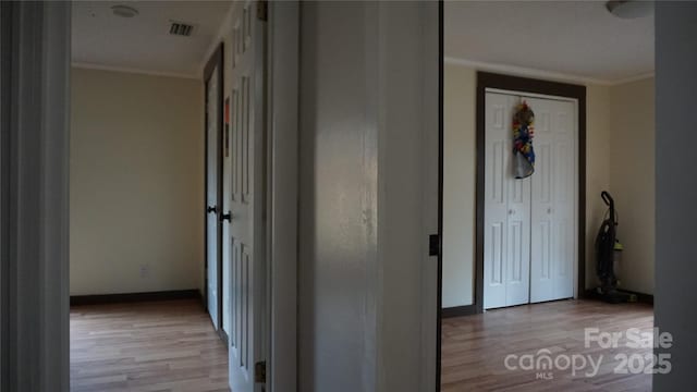 hall featuring light wood-type flooring and ornamental molding