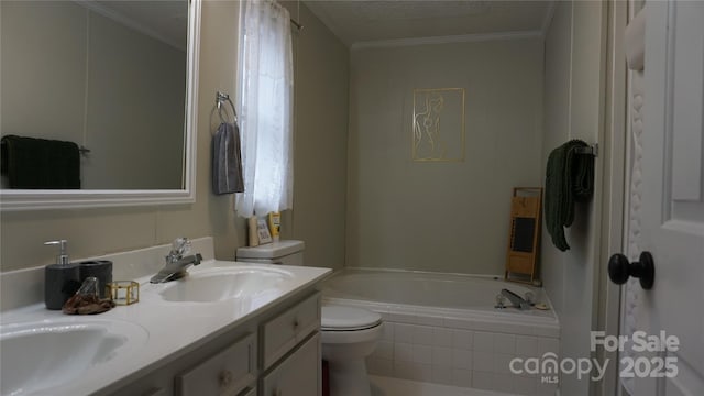 bathroom featuring tiled bath, a textured ceiling, toilet, vanity, and ornamental molding