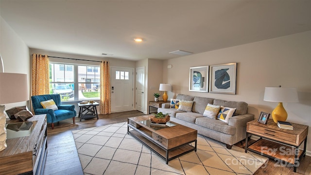 living area with light wood finished floors, baseboards, and visible vents