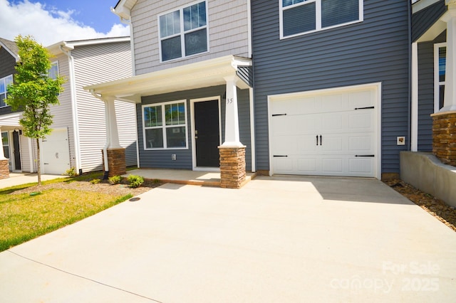 view of front of house with driveway, a porch, and a garage