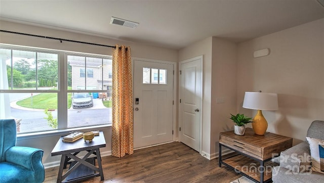 foyer featuring baseboards, dark wood-style flooring, and visible vents