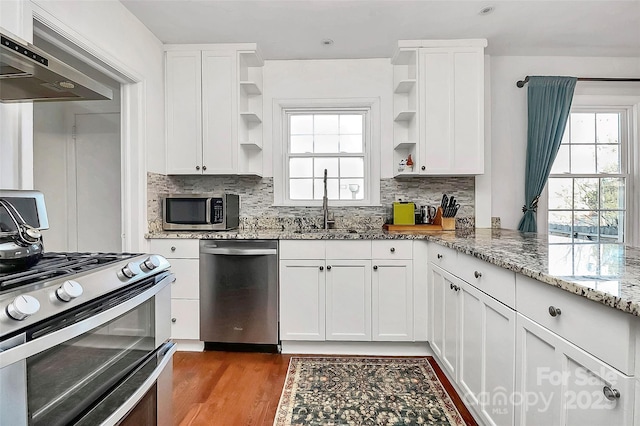 kitchen with white cabinets, sink, stainless steel appliances, and exhaust hood