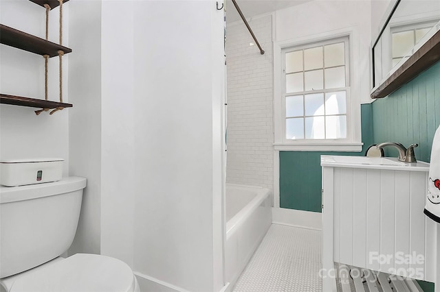 bathroom with tile patterned flooring, tiled shower / bath combo, and toilet