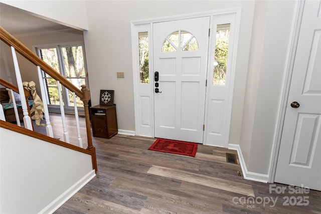 foyer featuring plenty of natural light, dark hardwood / wood-style flooring, and crown molding