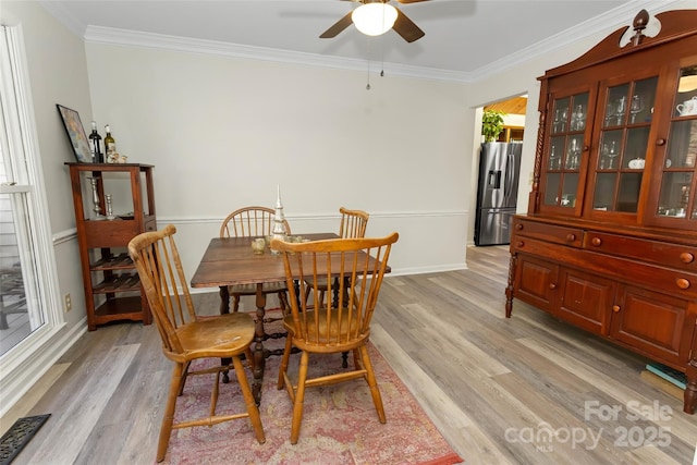 dining area with light hardwood / wood-style floors, ceiling fan, and ornamental molding