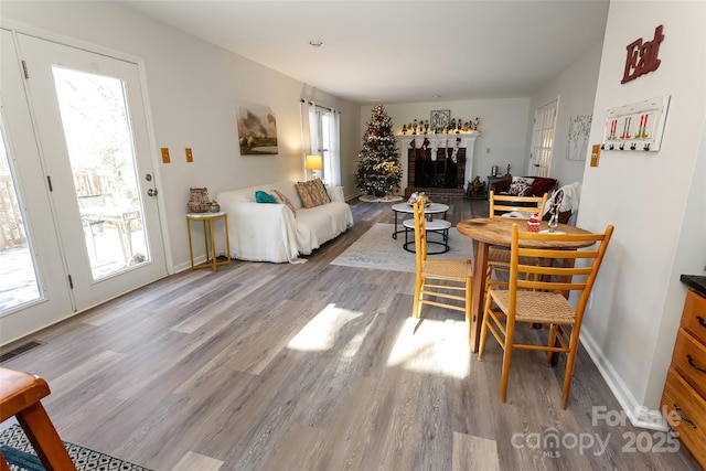 dining room featuring light hardwood / wood-style flooring and a brick fireplace