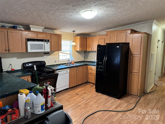 kitchen with crown molding, sink, black appliances, decorative light fixtures, and light hardwood / wood-style flooring