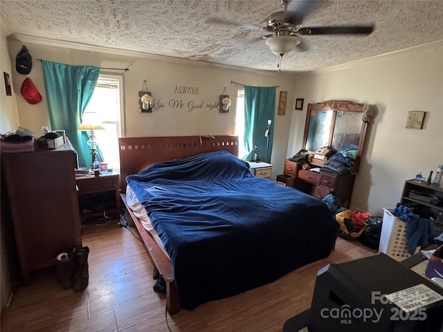 bedroom with a textured ceiling, hardwood / wood-style flooring, and ceiling fan