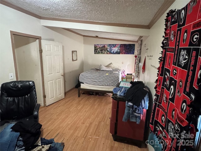 bedroom with a textured ceiling, hardwood / wood-style flooring, and crown molding