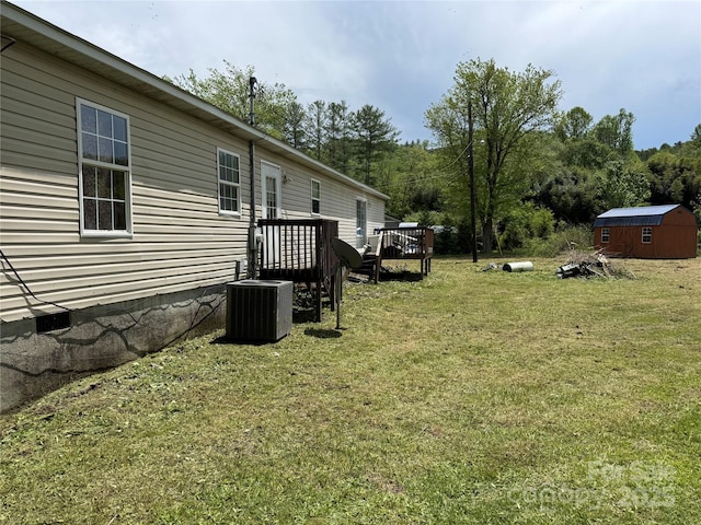 view of yard featuring a storage unit, a wooden deck, and an outdoor structure