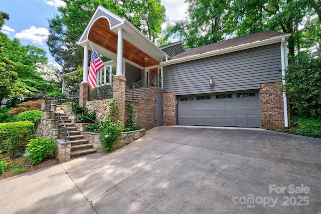 view of front facade with stairs, concrete driveway, and brick siding