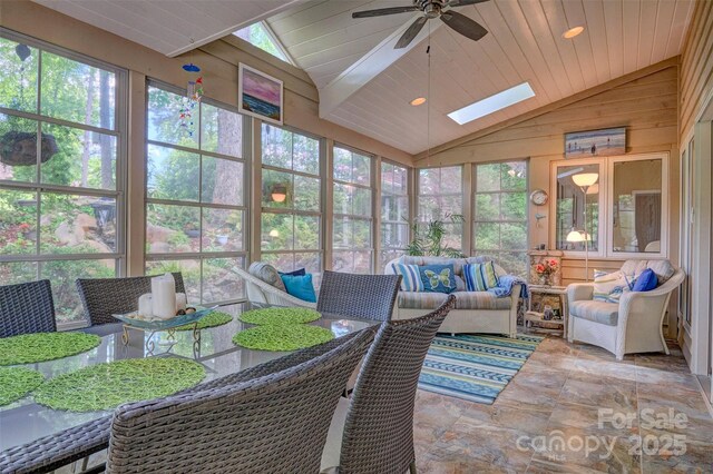 sunroom / solarium featuring ceiling fan, a healthy amount of sunlight, and lofted ceiling with skylight