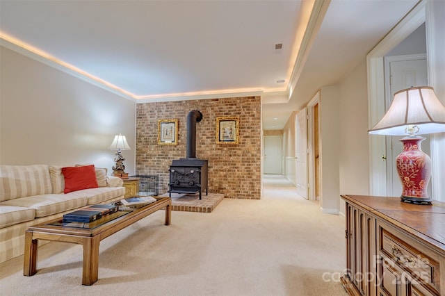 living room with a wood stove, light carpet, and ornamental molding