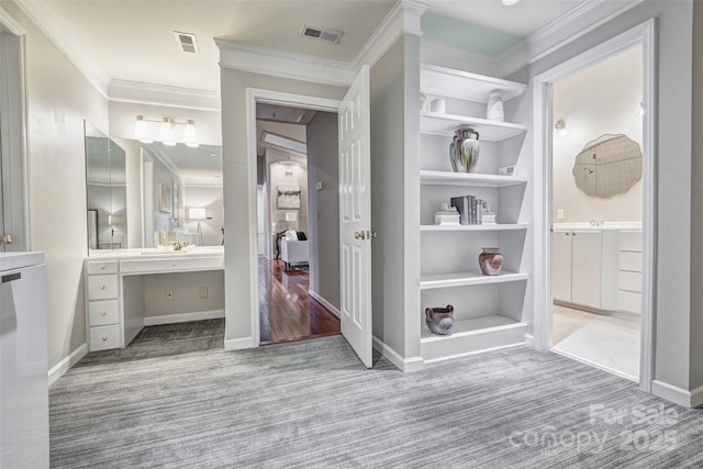 bathroom featuring vanity, visible vents, built in features, a closet, and crown molding