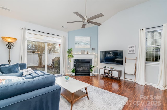 living room with ceiling fan, lofted ceiling, and dark hardwood / wood-style floors