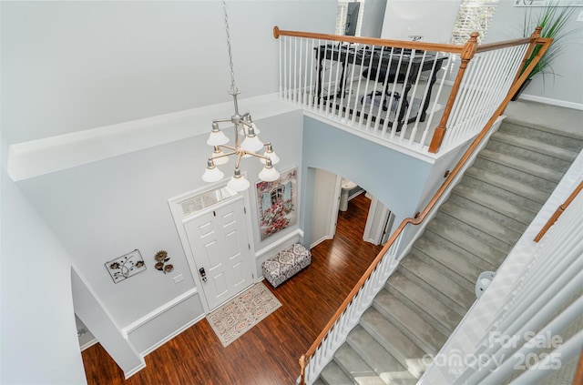 interior space featuring dark hardwood / wood-style flooring, a towering ceiling, and an inviting chandelier