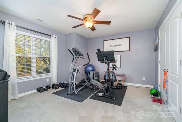 exercise area featuring light carpet and ceiling fan