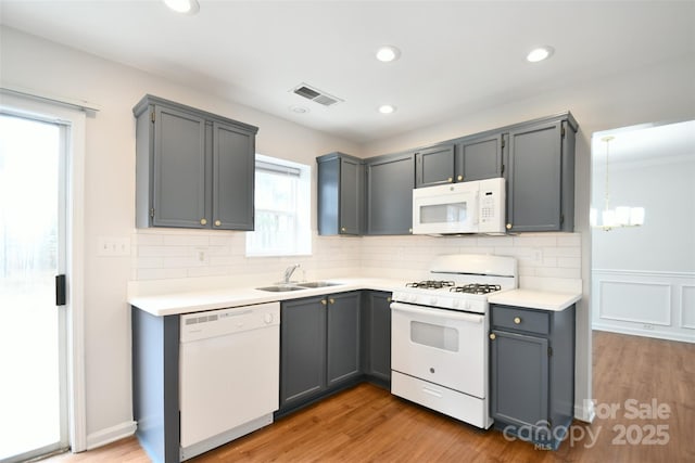 kitchen featuring gray cabinets, white appliances, and light countertops