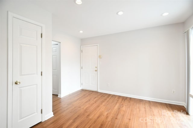 empty room featuring baseboards, recessed lighting, and light wood-style floors