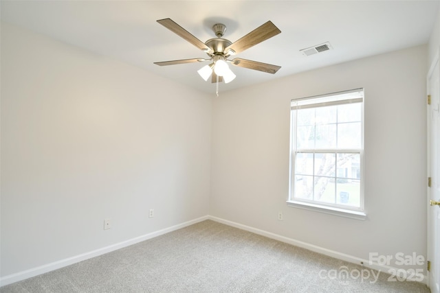 carpeted spare room featuring baseboards, visible vents, and a ceiling fan