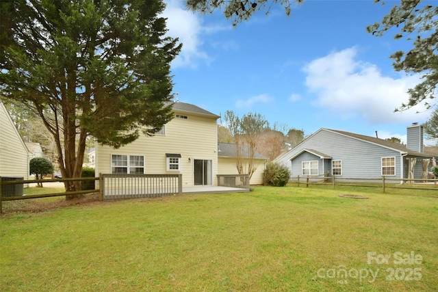 rear view of property featuring a lawn, a fenced backyard, and central air condition unit