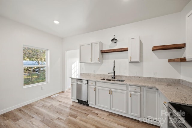 kitchen featuring sink, light wood-type flooring, appliances with stainless steel finishes, light stone counters, and white cabinetry