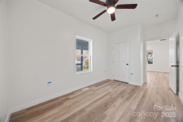 unfurnished bedroom with ceiling fan, light wood-type flooring, and a closet