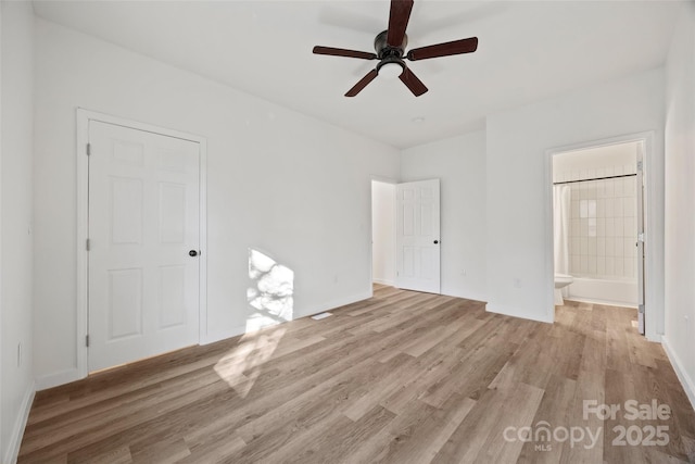 unfurnished bedroom with connected bathroom, light hardwood / wood-style flooring, and ceiling fan