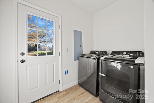 washroom with electric panel, light hardwood / wood-style floors, and independent washer and dryer