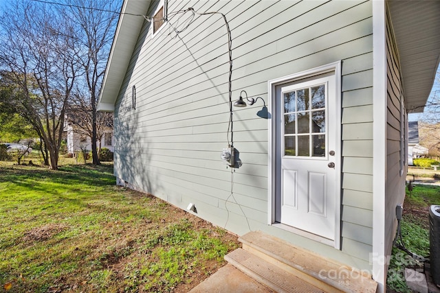 view of exterior entry with a lawn