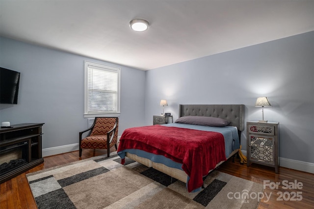 bedroom with dark hardwood / wood-style floors