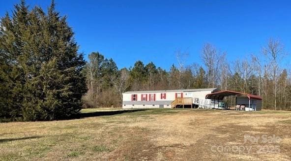 view of front of house with a front yard and a carport