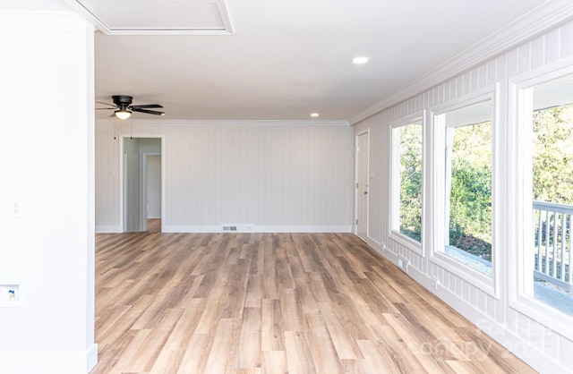 unfurnished room with a wealth of natural light, ornamental molding, and light hardwood / wood-style floors