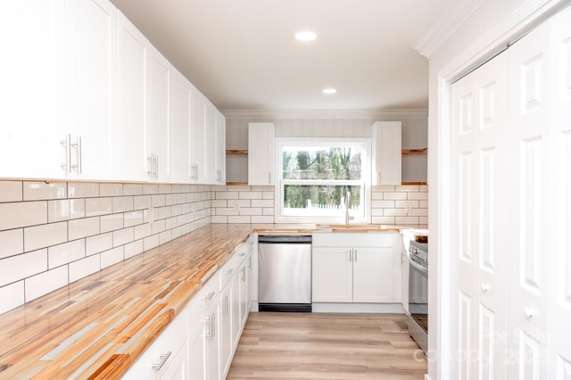 kitchen with sink, white cabinets, wooden counters, ornamental molding, and stainless steel appliances