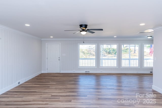 unfurnished room with ornamental molding, wood-type flooring, and a healthy amount of sunlight