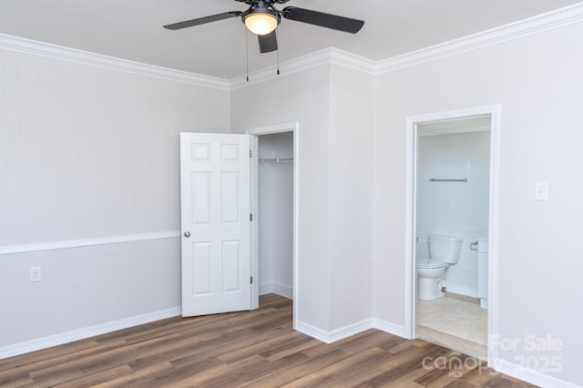 unfurnished bedroom with dark wood-type flooring, ornamental molding, a closet, and ensuite bathroom