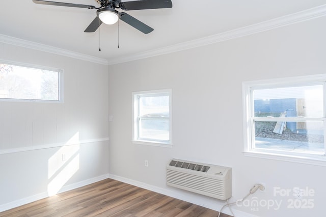 empty room featuring hardwood / wood-style flooring, a healthy amount of sunlight, crown molding, and an AC wall unit