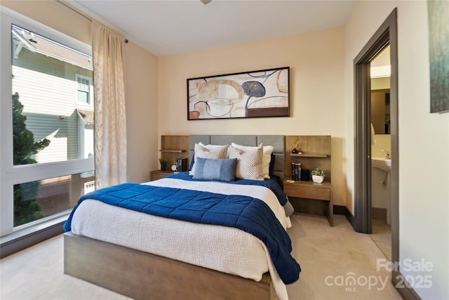 bedroom with light colored carpet and ensuite bath